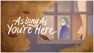 An illustration of an elderly woman in purple, with grey hair and no facial features other than glasses is seen behind a window, looking out. There is an autumn tree in front of the window, with leaves falling across the foreground and between the letters of the white logo reading "As Long As You're Here" 